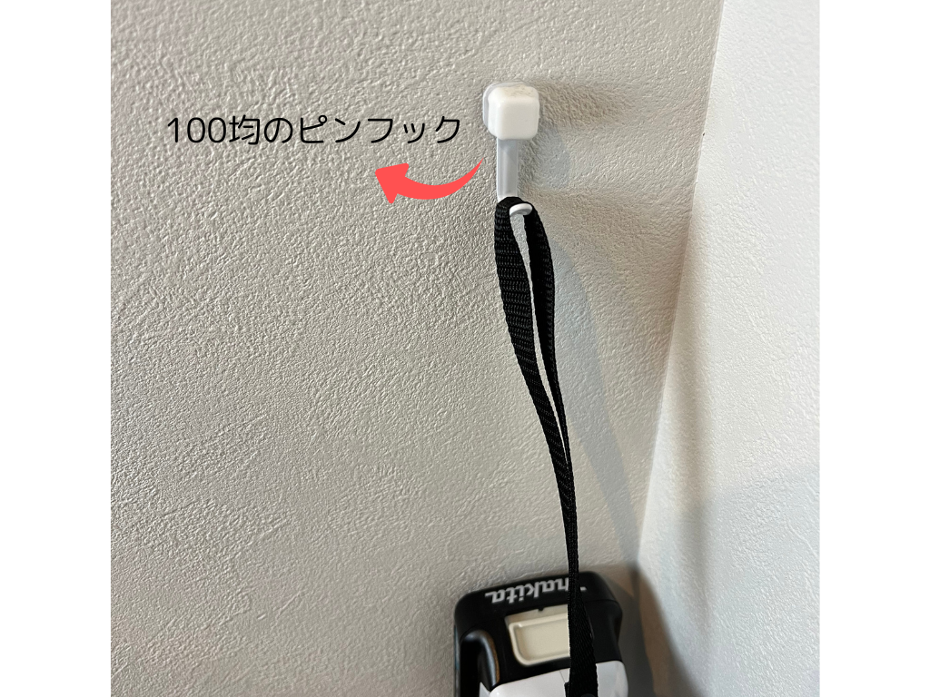 壁に取り付けた100均のピンフックに、マキタの掃除機CL107FDを吊るして収納している様子